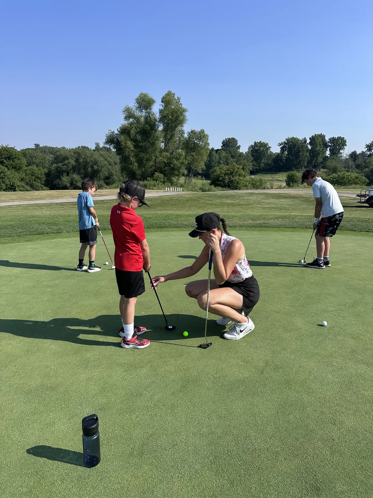 Junior golfers practicing putting with a coach at FireRock