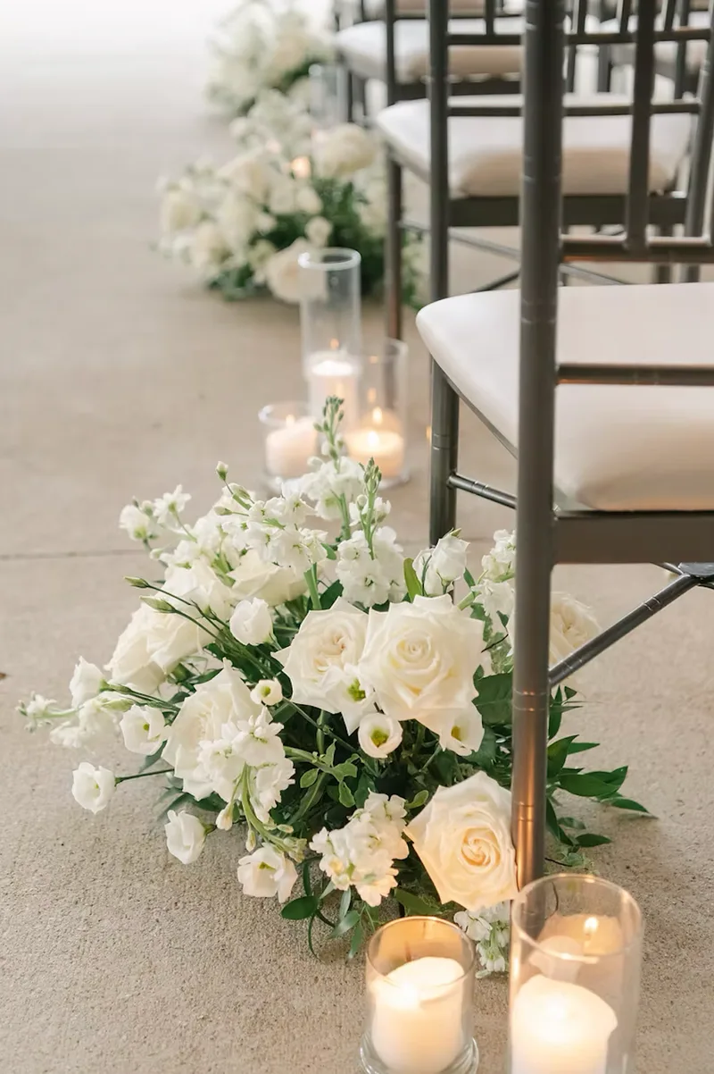 White flowers and candles lining a wedding ceremony aisle at FireRock